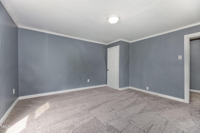 empty room featuring ornamental molding, carpet, and baseboards