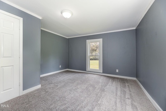 carpeted empty room featuring ornamental molding and baseboards