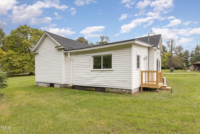 view of side of home featuring a yard and roof with shingles