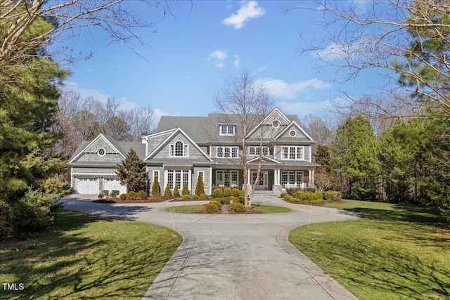 shingle-style home featuring driveway, an attached garage, a porch, and a front yard