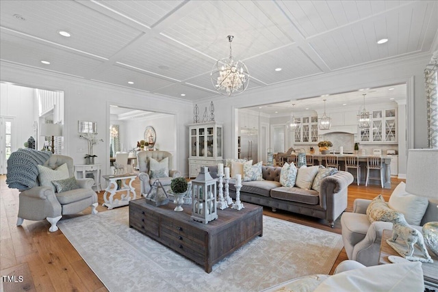 living room with coffered ceiling, wood-type flooring, and an inviting chandelier