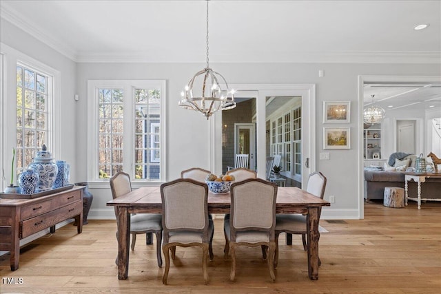 dining room with an inviting chandelier, plenty of natural light, light wood finished floors, and crown molding