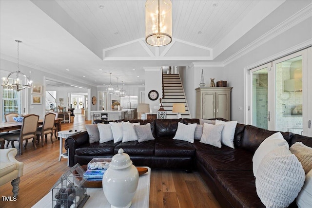 living area featuring plenty of natural light, a notable chandelier, and stairs