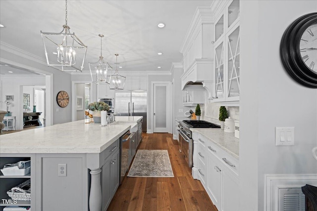 kitchen featuring white cabinets, a spacious island, built in appliances, crown molding, and gray cabinetry