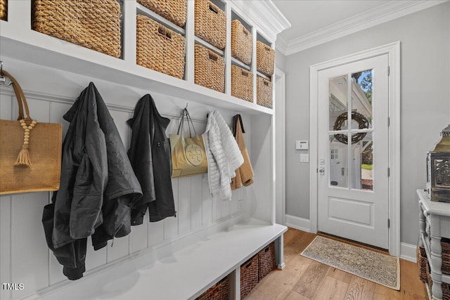 mudroom with ornamental molding, light wood-style floors, and baseboards