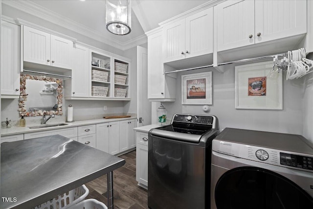 laundry area with cabinet space, dark wood-type flooring, washing machine and dryer, ornamental molding, and a sink