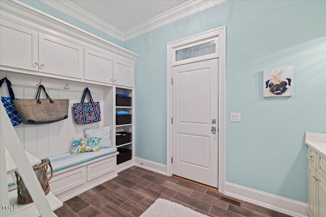 mudroom featuring ornamental molding, wood finish floors, visible vents, and baseboards