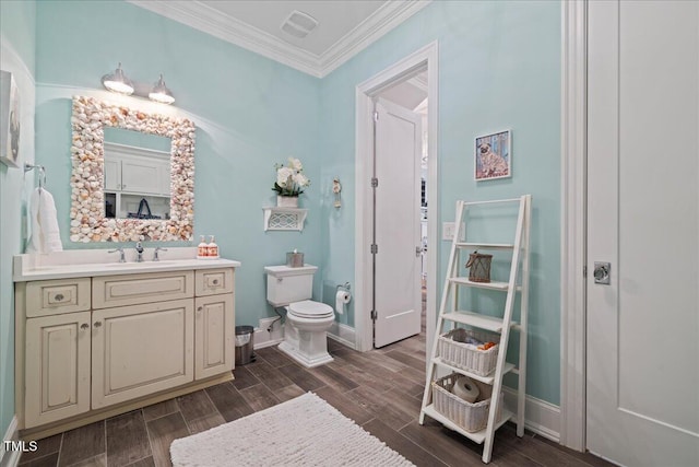 bathroom with toilet, wood finish floors, visible vents, vanity, and crown molding