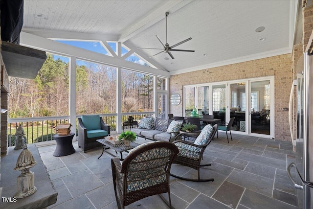 sunroom / solarium featuring lofted ceiling with beams, plenty of natural light, and ceiling fan