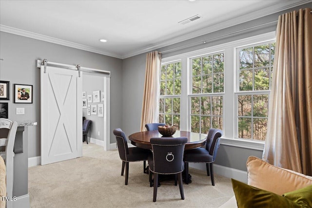 dining room featuring light colored carpet, visible vents, a barn door, ornamental molding, and baseboards