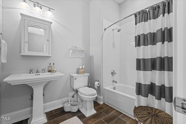 bathroom with toilet, shower / tub combo, baseboards, and wood finish floors