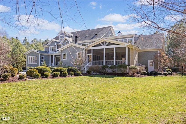 view of front of home with a chimney, a front yard, and a sunroom