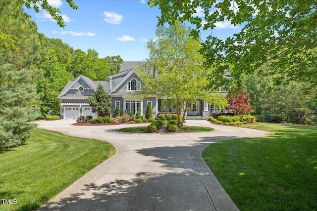view of front facade featuring curved driveway, a front lawn, and a garage