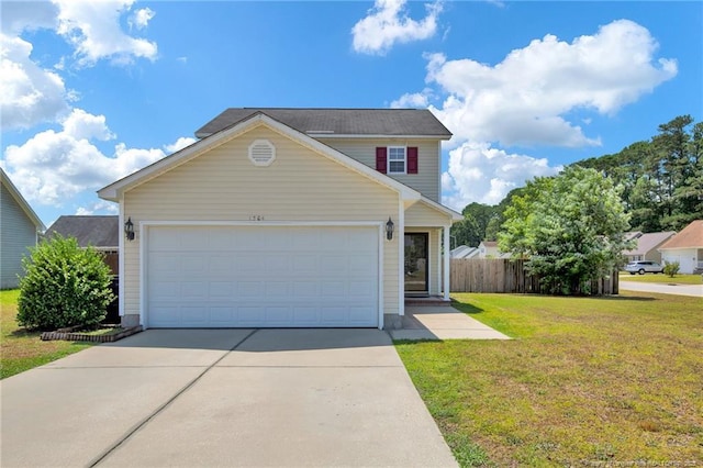 traditional-style home featuring an attached garage, driveway, fence, and a front yard