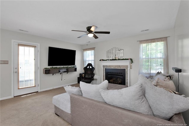 living area featuring carpet floors, a fireplace, visible vents, a ceiling fan, and baseboards