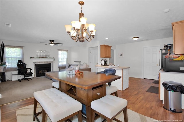 dining space with plenty of natural light, a fireplace, visible vents, and light wood-style flooring