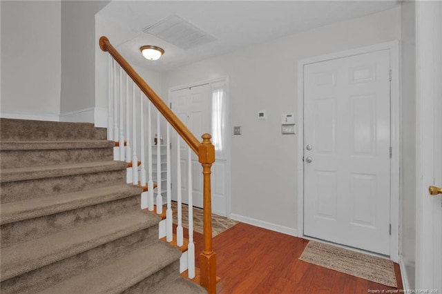 foyer featuring stairs, baseboards, and wood finished floors