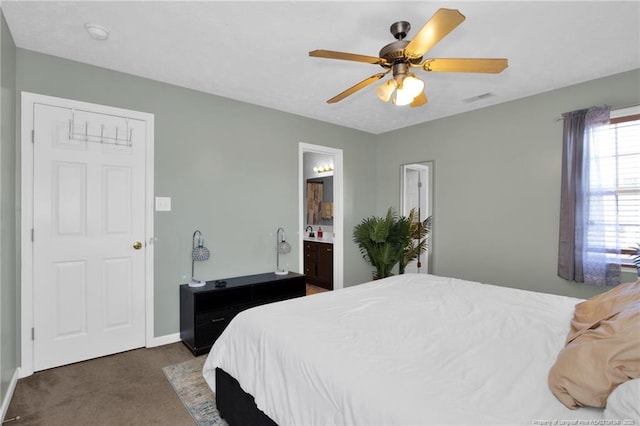 bedroom with baseboards, visible vents, connected bathroom, ceiling fan, and dark colored carpet