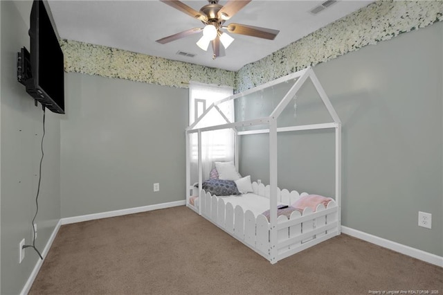 unfurnished bedroom with a ceiling fan, carpet, visible vents, and baseboards