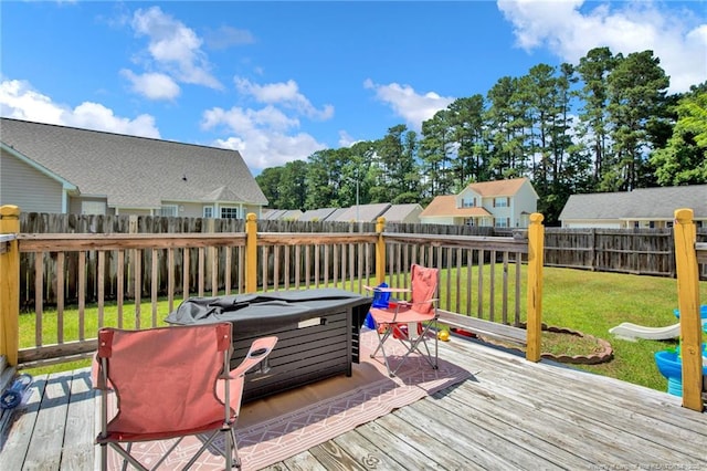 wooden terrace featuring a fenced backyard and a lawn