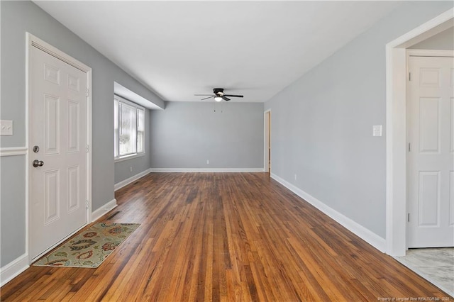 unfurnished room featuring ceiling fan, baseboards, and wood finished floors