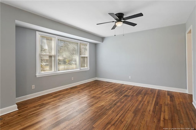 spare room with dark wood-type flooring, visible vents, baseboards, and a ceiling fan