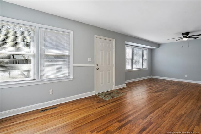 interior space with visible vents, ceiling fan, baseboards, and wood finished floors