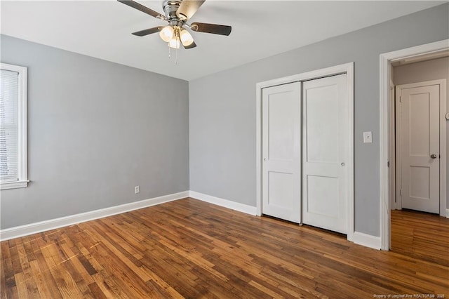 unfurnished bedroom featuring ceiling fan, baseboards, a closet, and wood finished floors