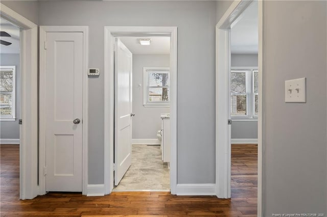 corridor featuring wood finished floors and baseboards