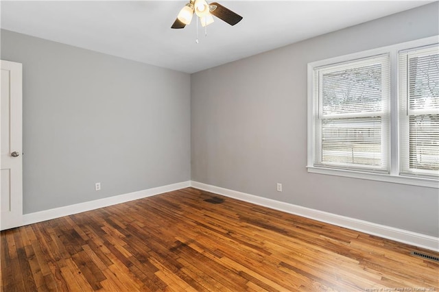 empty room with light wood finished floors, baseboards, visible vents, and a ceiling fan