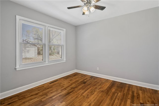 spare room featuring a ceiling fan, wood-type flooring, visible vents, and baseboards