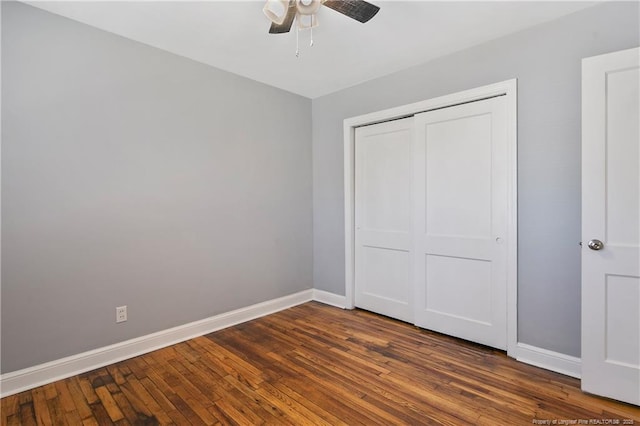 unfurnished bedroom featuring dark wood-style floors, a closet, ceiling fan, and baseboards