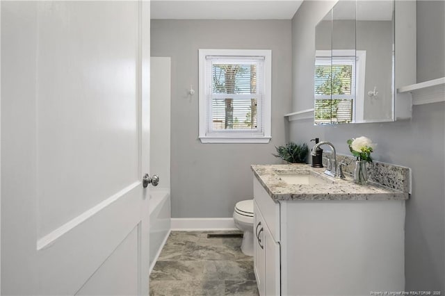 bathroom featuring toilet, baseboards, and vanity