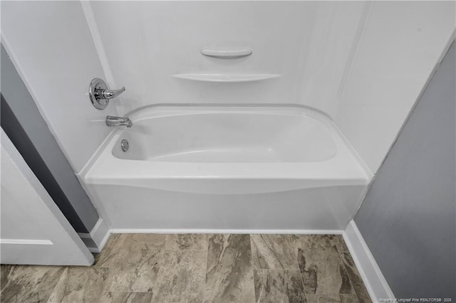 full bath featuring baseboards