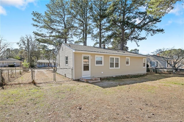 back of property featuring a yard, a gate, and fence