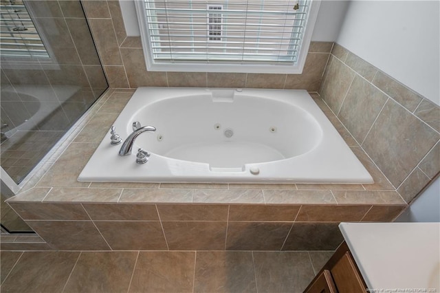 full bath featuring a tile shower, vanity, and a tub with jets