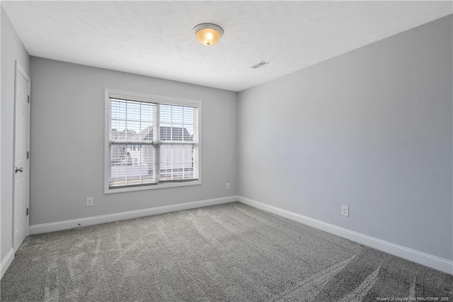 unfurnished room featuring carpet floors, visible vents, a textured ceiling, and baseboards