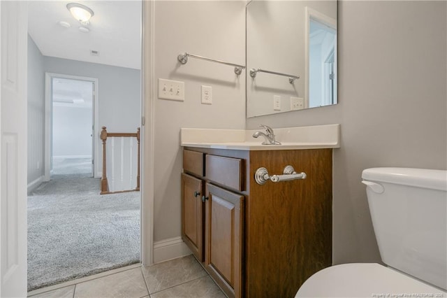 bathroom featuring tile patterned flooring, baseboards, vanity, and toilet