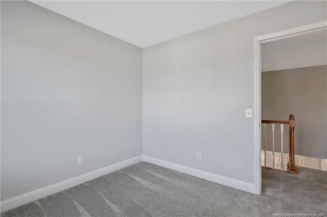 spare room featuring carpet floors and baseboards