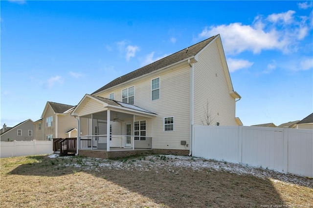 back of house featuring a ceiling fan, a fenced backyard, and a yard