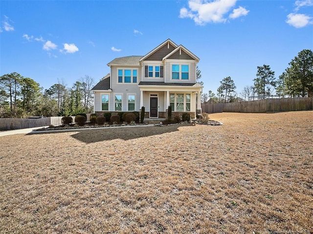 craftsman house featuring stone siding and fence