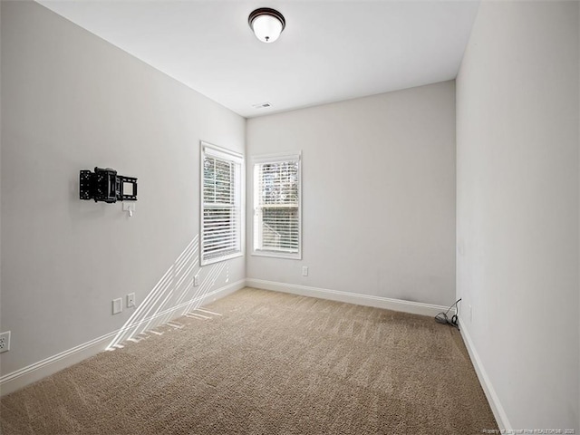 spare room featuring carpet and baseboards