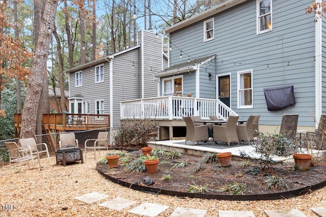 rear view of property with an outdoor fire pit, a patio area, and a wooden deck