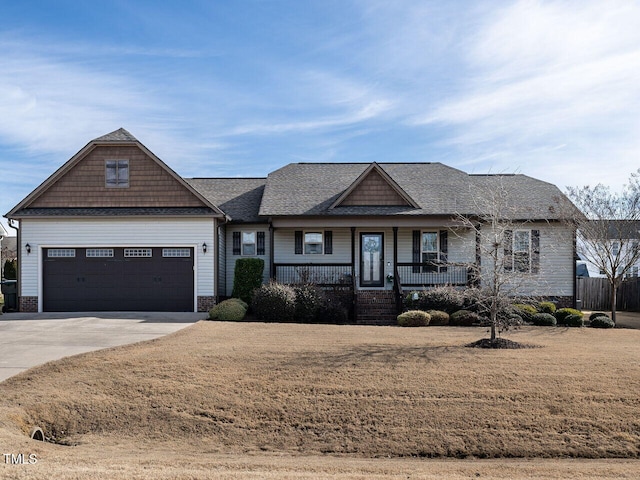 view of front facade featuring covered porch, a shingled roof, and concrete driveway