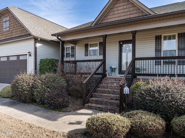 view of front of home with a porch, a shingled roof, and a garage