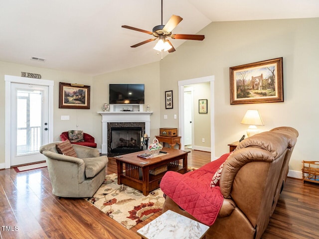 living room with lofted ceiling, a fireplace, wood finished floors, visible vents, and baseboards