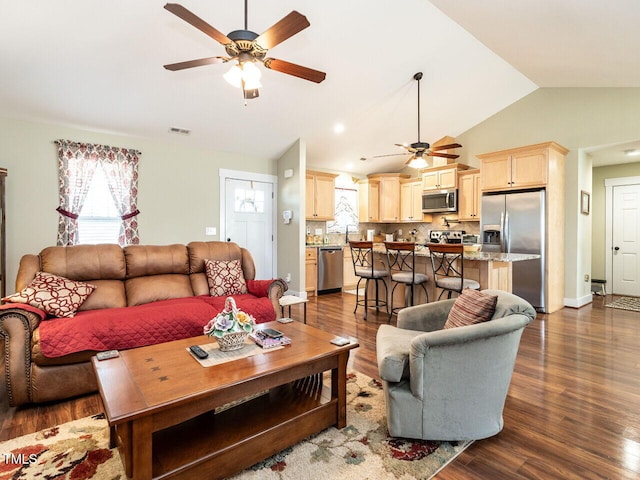 living area with a ceiling fan, dark wood finished floors, visible vents, and vaulted ceiling