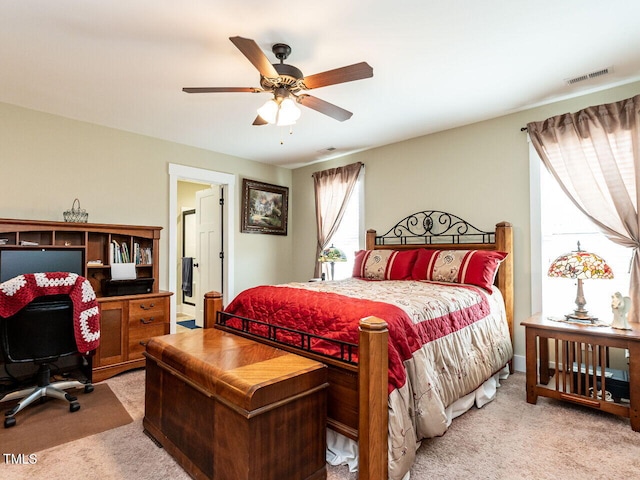 bedroom featuring a ceiling fan, light colored carpet, and visible vents