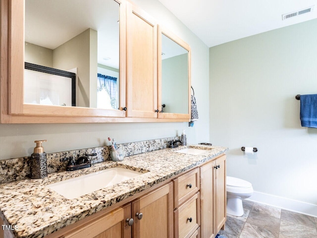 bathroom with toilet, a sink, visible vents, and baseboards