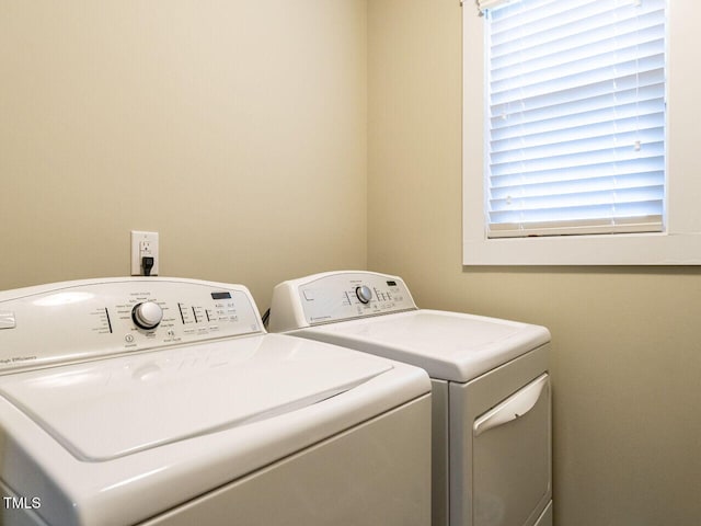 washroom featuring laundry area, separate washer and dryer, and plenty of natural light